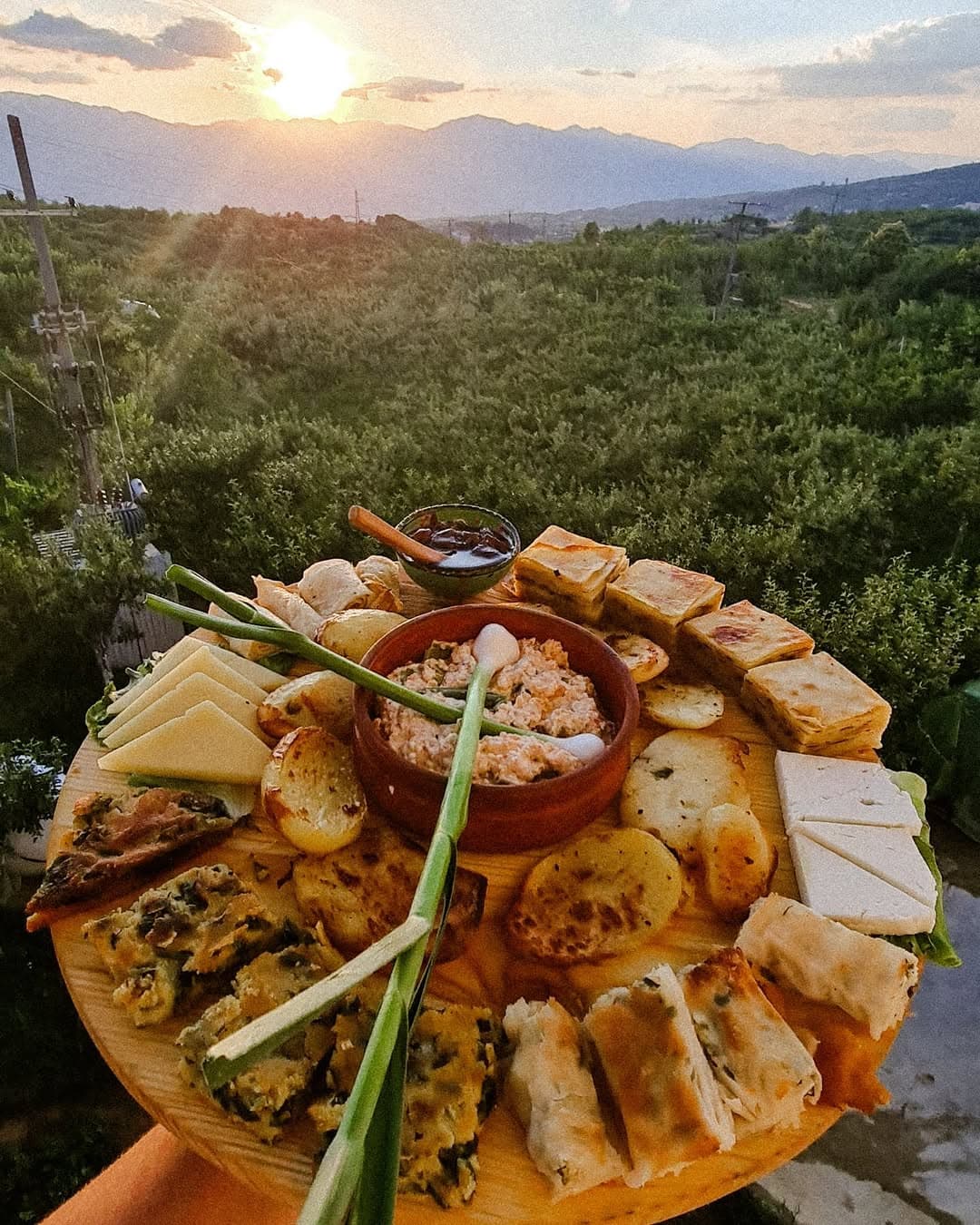 Traditional Albanian food platter with local dishes at sunset in Peshkopia