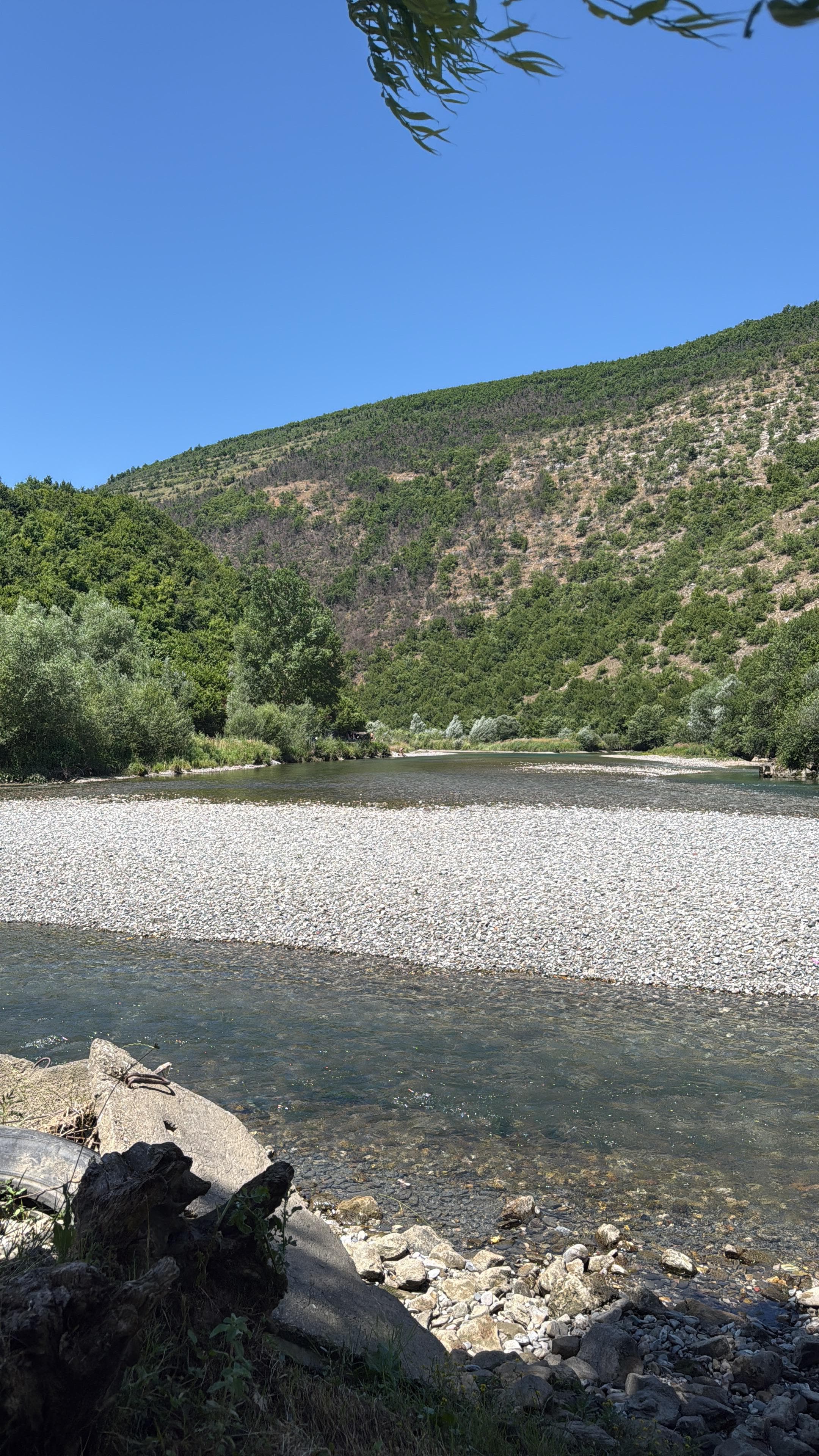 Crystal clear waters of the Black Drin River with a pebble beach in Albania