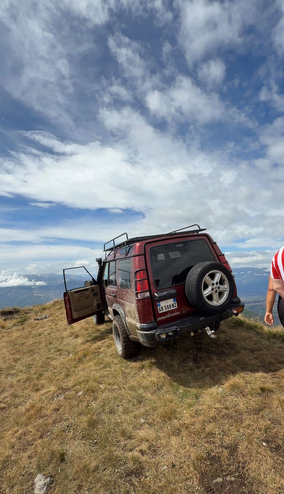 Red Land Rover Discovery parked at a mountain summit in Albania